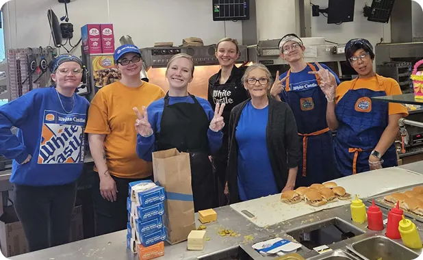 Group of White Castle employees smiling behind the counter.