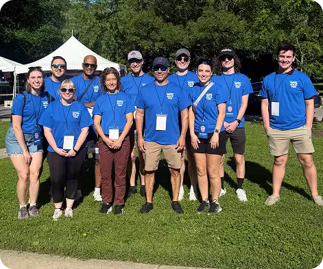 White Castle volunteers pose together outdoors at a community event wearing matching blue shirts.