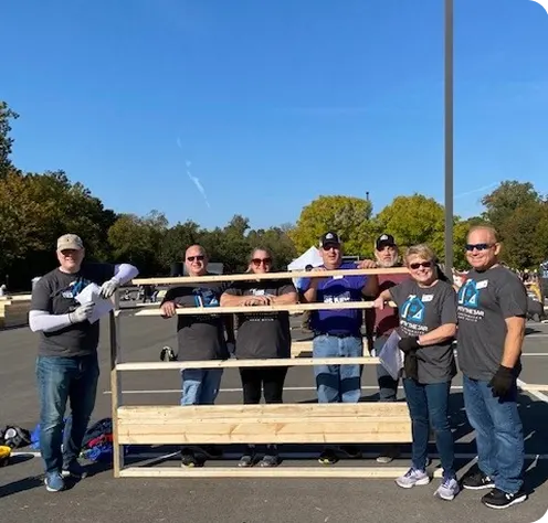 White Castle volunteers pose with a completed project during a community service event outdoors.